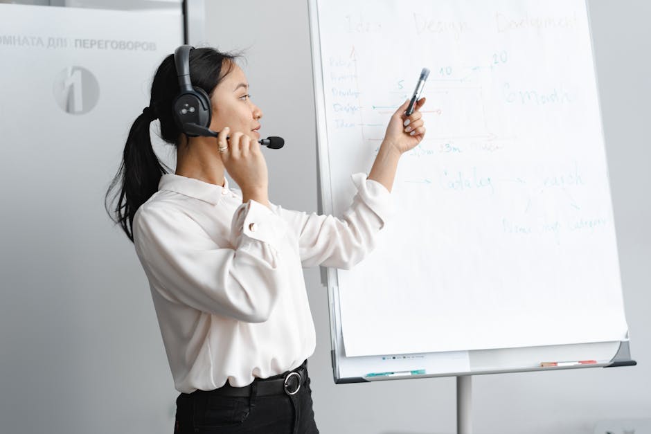 Asian woman presenting ideas on a whiteboard in a corporate office.