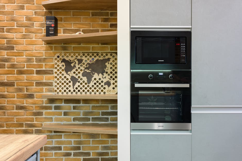 Stylish kitchen design featuring brick wall, shelves, and built-in appliances.